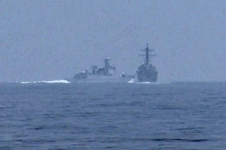 　３日、台湾海峡で米海軍のミサイル駆逐艦（右）に接近する中国軍艦（グローバルニュース提供・ロイター＝共同）