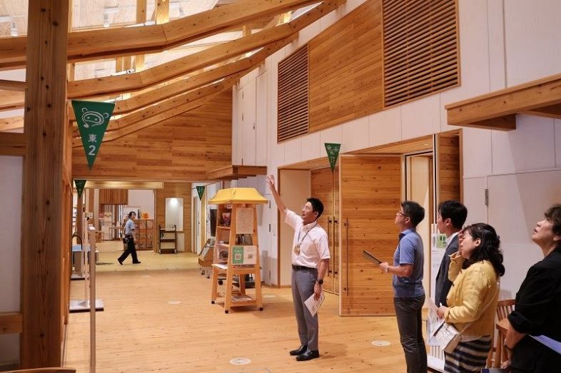 西粟倉村の木材をふんだんに使った「あわくら会館」を視察する岡山経済同友会のメンバーら