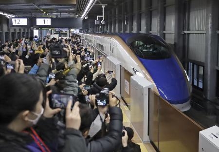 　３月１６日、北陸新幹線が延伸開業しＪＲ福井駅に到着した東京行きの一番列車を出迎える大勢の人たち＝福井市