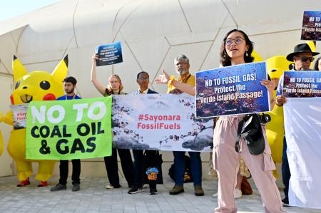 　ＣＯＰ２８の会場で、日本の化石燃料への公的拠出に抗議する集会参加者ら＝４日、アラブ首長国連邦のドバイ（共同）