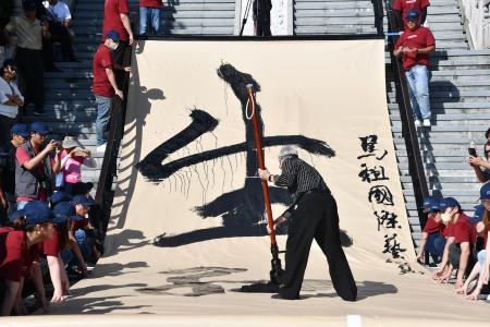 　２３日、台湾・馬祖列島の南竿で行われた「馬祖国際芸術島」の開幕式で書を披露する人（共同）