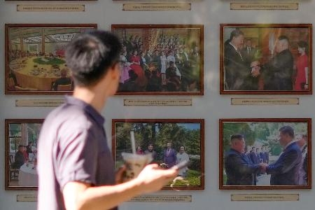　北京市内の北朝鮮大使館前に掲示されている金正恩朝鮮労働党総書記と中国の習近平国家主席が一緒に写った写真＝２２日（共同）