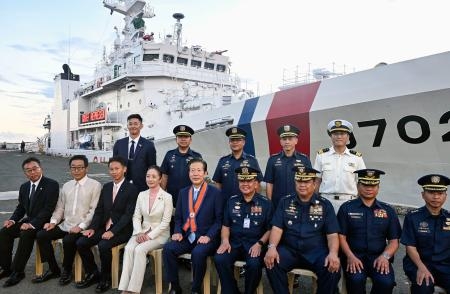 　フィリピン沿岸警備隊の巡視船前で記念撮影する公明党の山口代表（前列中央）ら＝１７日、マニラ（共同）