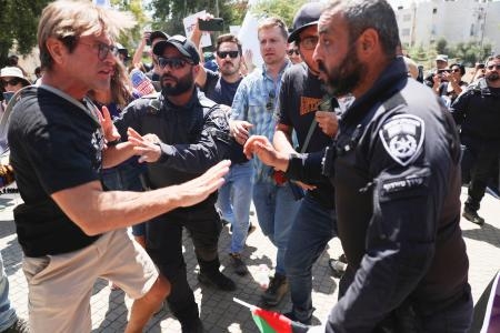 　ヨルダン川西岸のユダヤ人入植地キリヤトアルバで、警察官ともみ合うデモ参加者（左）＝２５日（共同）