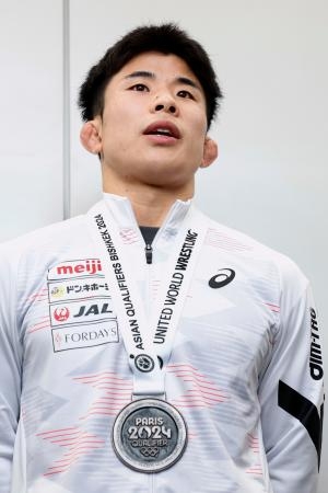 　レスリングの男子グレコローマン６７キロ級でパリ五輪代表に決まり、取材に応じる曽我部京太郎＝２３日、成田空港