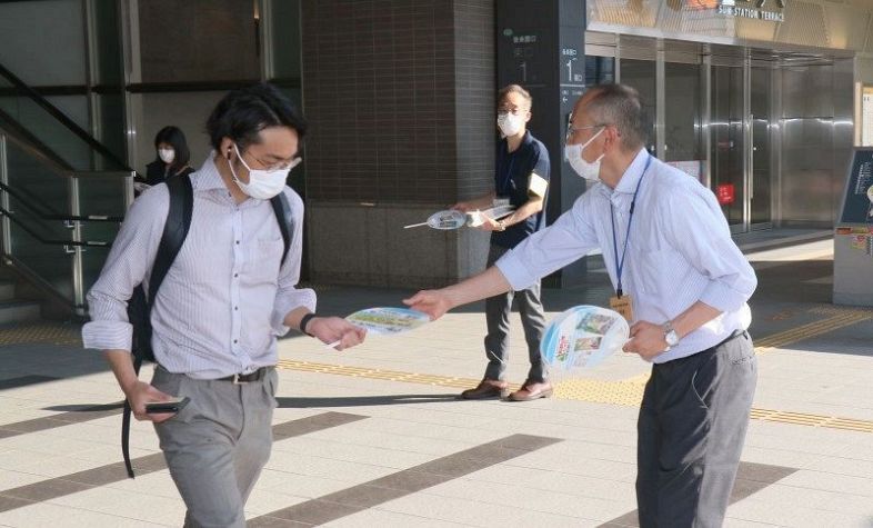 うちわを配って土砂災害への備えを呼びかける岡山県職員（右）