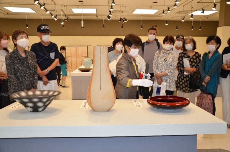 第６５回日本伝統工芸中国展会場で、出品作家の列品解説に聞き入るファンら