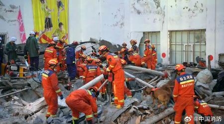 　中学校の体育館の屋根が崩落した現場で救助活動を行う消防隊員ら＝２３日、中国黒竜江省チチハル市（中国消防の「微博（ウェイボ）」から、共同）