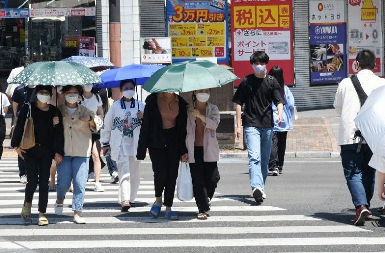 強い日差しの中、日傘を差す女性ら＝２９日午後１時３５分、ＪＲ岡山駅周辺