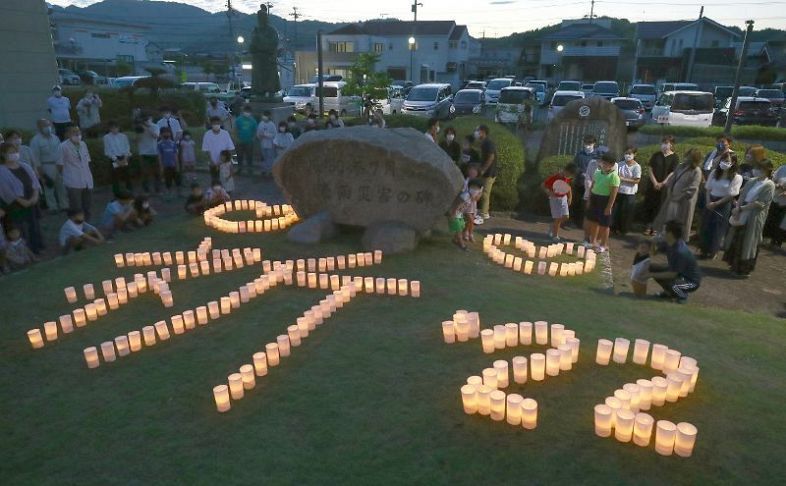 キャンドルで「祈　２２」と描き追悼する人々