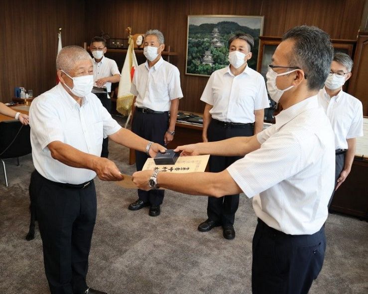 檜垣本部長から協力章を伝達される大橋さん（左）