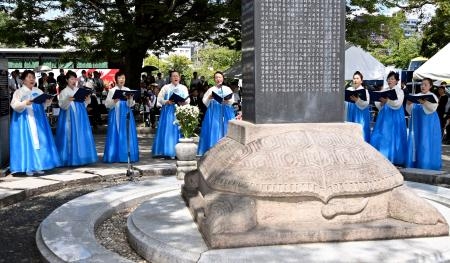　広島市の平和記念公園で営まれた韓国人被爆者の慰霊祭で、民族衣装姿で慰霊歌を歌う女性たち＝５日午前
