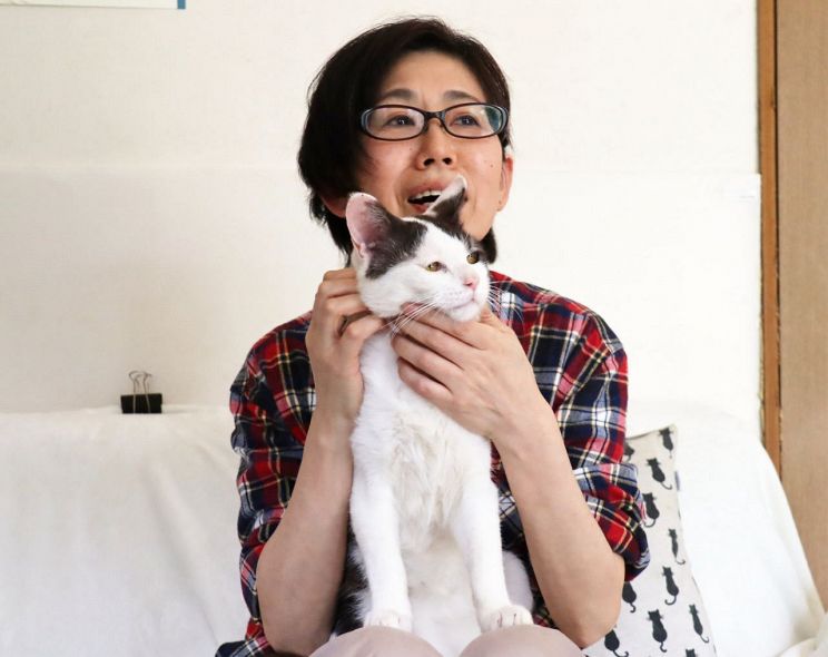 保護した猫を抱く吉田さん。殺処分ゼロを目指し活動している