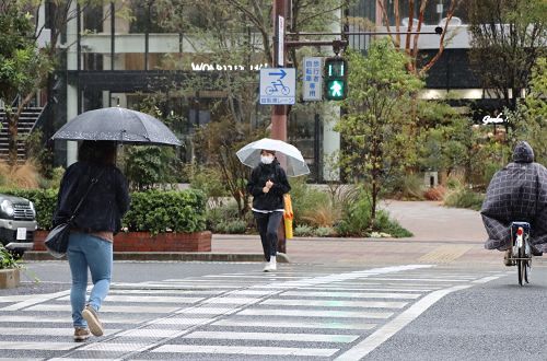 ジャンパーなどを着て横断歩道を渡る人たち＝７日午前１０時２０分、岡山市北区柳町