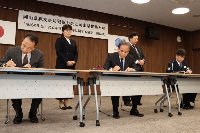 協定書に署名する（左から）荻野部長、中村会長、井上部長