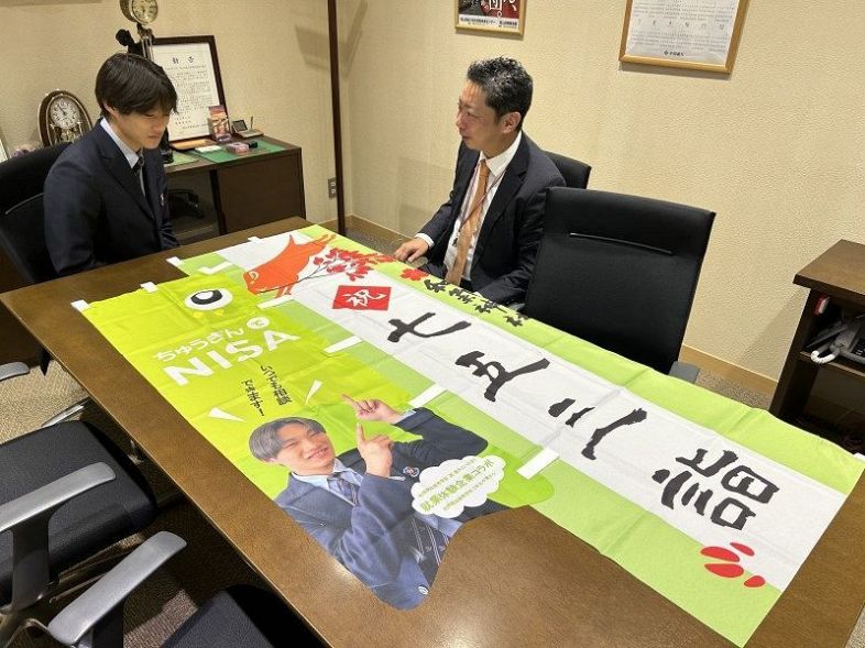 和気閑谷高生がデザインしたのぼり旗。中国銀行和気支店には中家さん（左）が届けた