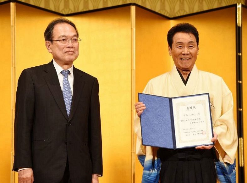 浜田理事長（左）から委嘱状を手渡され、笑顔の五木さん＝東京都内
