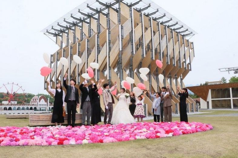 パビリオン棟「風の葉」前で紙風船を空に飛ばして結婚を祝う新郎新婦ら