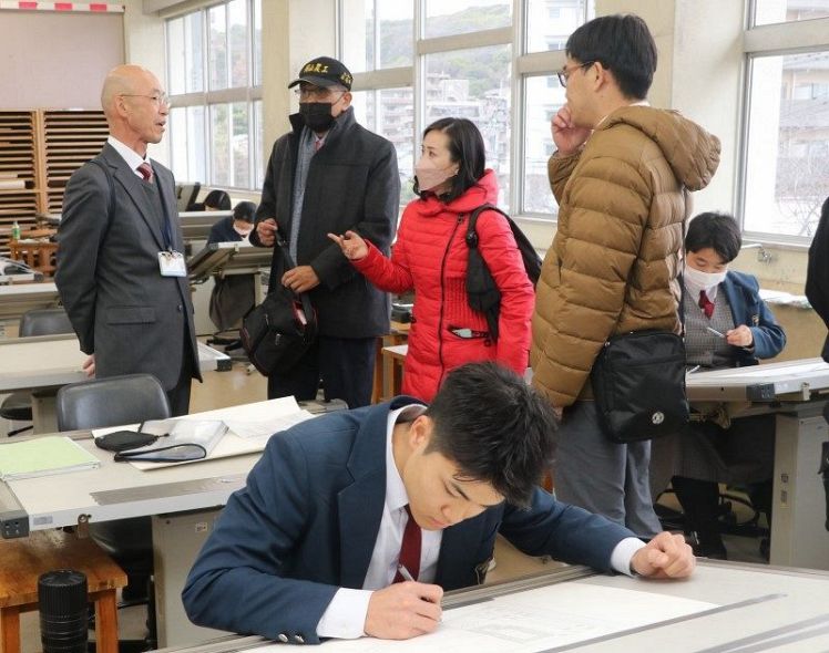 岡山工業高の文谷校長（左端）の説明を受け、実習を見学する国立岡山高級農工職業学校の教員ら