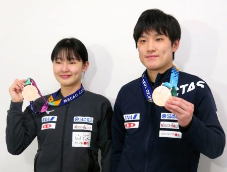　卓球のシングルスのワールドカップから帰国し、メダルを見せる張本智和（右）と妹美和＝２２日、成田空港