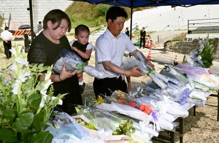 　西日本豪雨から５年となり、広島市安芸区の被災した団地に設けられた献花台に花を供える人たち＝６日午後