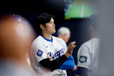 　韓国プロ野球キウム戦のベンチでチームメートと話すドジャース・大谷＝ソウル（共同）