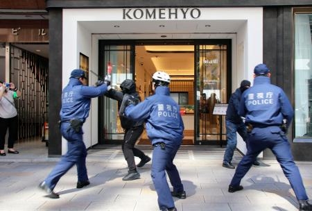 　警視庁が実施した強盗対処訓練で、犯人役を制圧する警察官＝２４日午前、東京・銀座