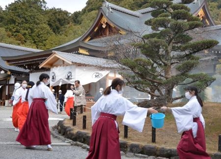 　大神神社で実施された防火訓練で、バケツリレーをする巫女や職員ら＝２３日午後、奈良県桜井市