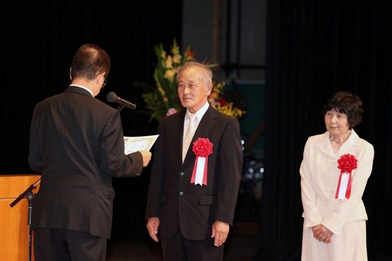 金婚夫婦を代表して祝辞状を受け取る小川陽生さん（中央）、善子さん夫妻