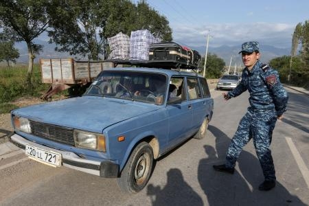 　２４日、アルメニア南東部の村の検問所を車で通過するナゴルノカラバフからの避難民（ロイター＝共同）