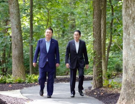 　日米韓首脳会談を前に、記念撮影に向かう岸田首相（右）と尹錫悦韓国大統領＝１８日、ワシントン近郊・キャンプデービッド（共同）
