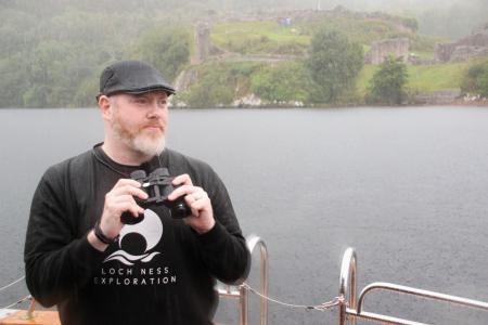 　英北部ネス湖で、ネッシーの大捜索を控え、船上から湖面を眺めるアラン・マッケーナさん＝２５日（共同）