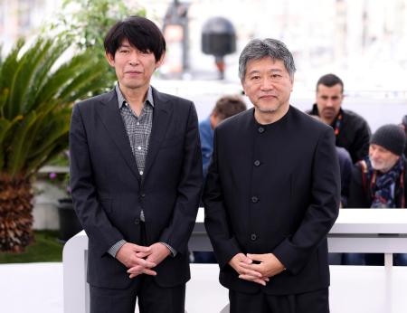 　１８日、カンヌ国際映画祭で写真撮影に応じる映画「怪物」で脚本を担当した坂元裕二さん（左）と是枝裕和監督。坂元さんは脚本賞を受賞した＝フランス・カンヌ（ＡＰ＝共同）