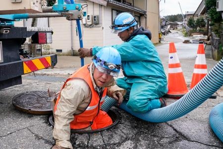 　下水管の復旧のため、点検と清掃をする作業員＝３月２９日、石川県珠洲市