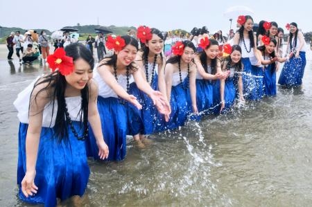 　海開きし、水遊びを楽しむ地元高校のフラダンス部員＝１５日午前、福島県いわき市の四倉海水浴場