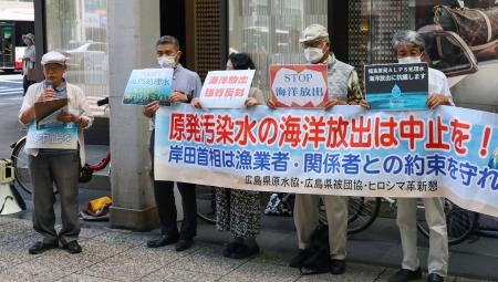 　広島市で開かれた、東京電力福島第１原発の処理水放出に反対する集会。左端は広島県原爆被害者団体協議会の佐久間邦彦理事長＝２４日午後