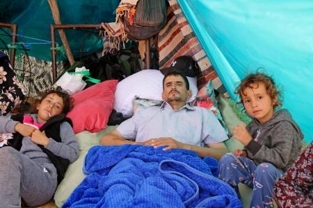 　１５日、モロッコ中部の山間部の集落に作ったテントで、取材に答えるアブデルハフィド・オブラヒムさん（中央）。左右は生き残った２人の娘（共同）