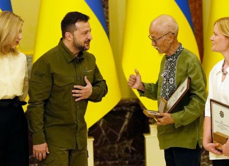 　ウクライナのゼレンスキー大統領（左から２人目）から賞を受ける邦人ボランティアの土子文則さん＝２３日、キーウ（共同）