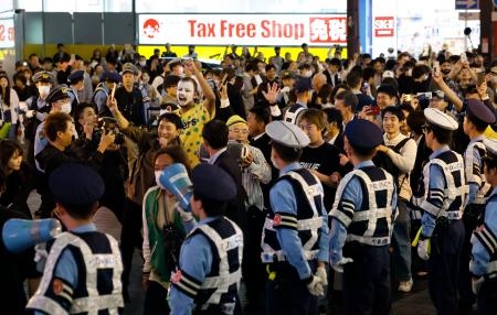 　プロ野球阪神が日本シリーズ進出を決め、警察官が警備する中、大阪・道頓堀で盛り上がる人たち＝２０日夜