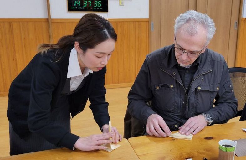 鶴の折り方を教える柿元さん（左）