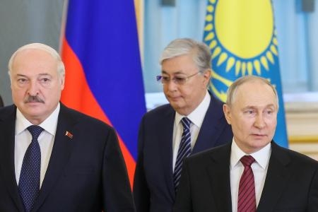 　ユーラシア経済同盟首脳会議で顔を合わせた（左から）ベラルーシのルカシェンコ大統領とカザフスタンのトカエフ大統領、ロシアのプーチン大統領＝２５日、モスクワ（タス＝共同）