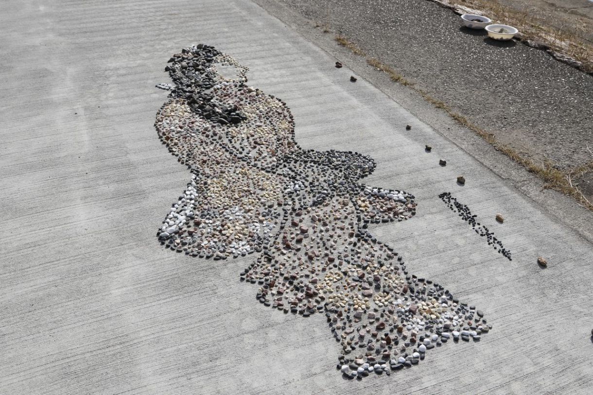 自然石で見返り美人図 名画再現　岡山・旭川河川敷で画家三宅さん