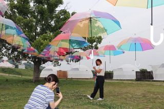 梅雨空に浮かぶ虹色の傘１００本　倉敷のグランピング施設で展示